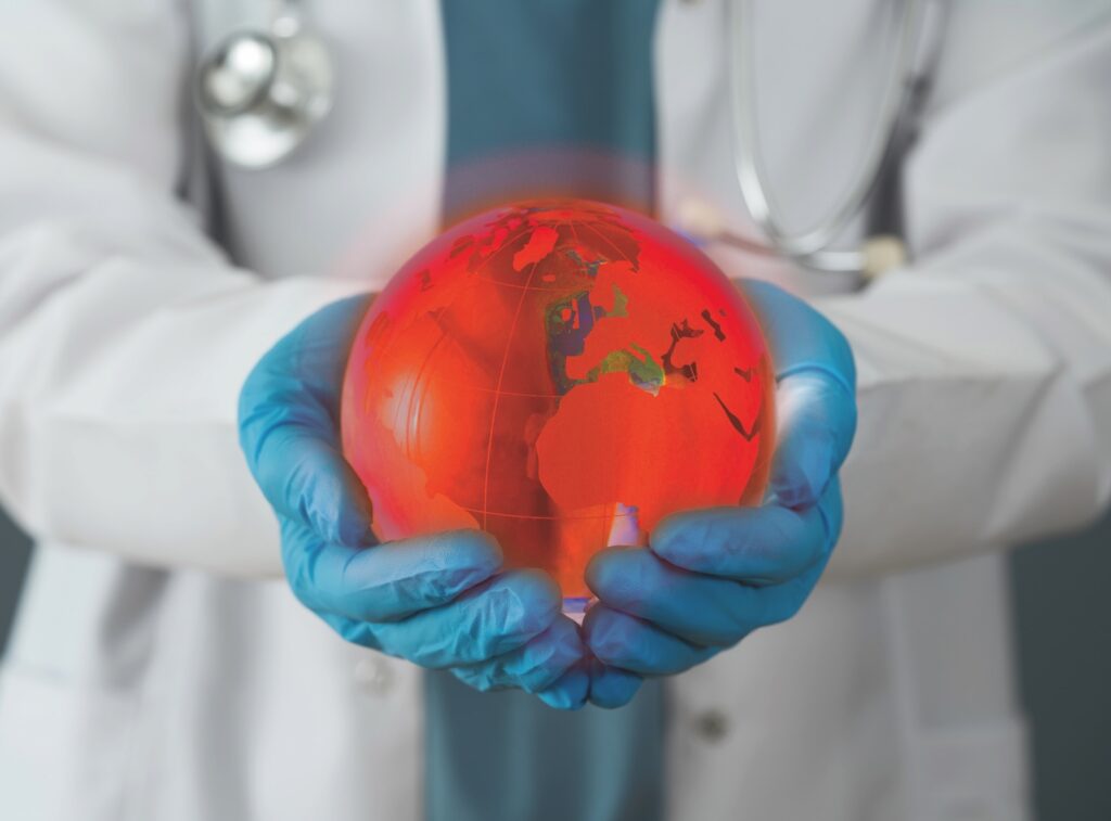 Doctor in white coat and surgical gloves holding a glowing globe.