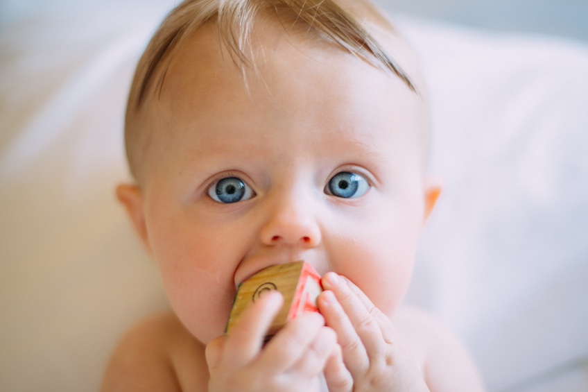 Close up of baby with toy in mouth